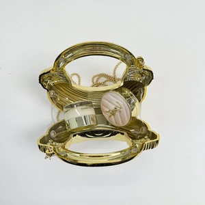 Macro view of golden shell-shaped metal clutch bag with vertical radial stripes and chain