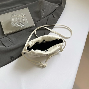 Chic cream leather drawstring bucket bag with magnetic closure and crossbody strap