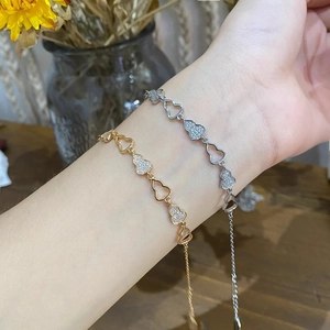 Vue détaillée des bracelets en forme de cœur évidé et pavé de zircons or et argent