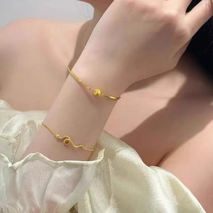 Elegant gold snake wrap chain bracelet and beaded bangle set for women on model wrist