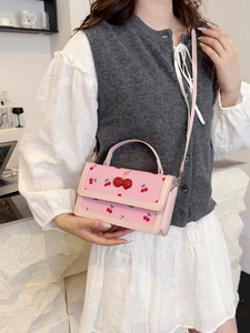 Borsa a tracolla rosa con stampa ciliegia e paillettes su camicia bianca