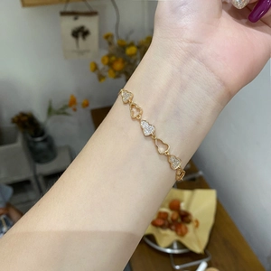 Bracelet Wulu doré orné de pierres brillantes au poignet dans un décor de vie