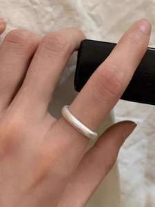 Macro detail of minimalist matte silver open ring featuring a brushed texture finish