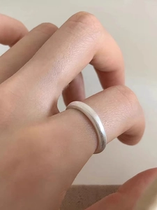 Close-up of minimalist silver butterfly ring with matte brushed finish and open design