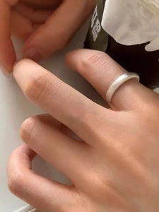 Detail of a matte silver adjustable butterfly ring worn on index finger for daily wear