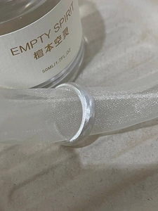 Close-up of minimalist silver butterfly ring with brushed metal texture on soft tulle