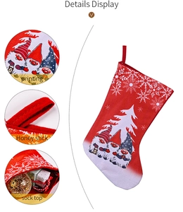 Detail view of large red Christmas stocking featuring three festive gnome prints and hanging loop