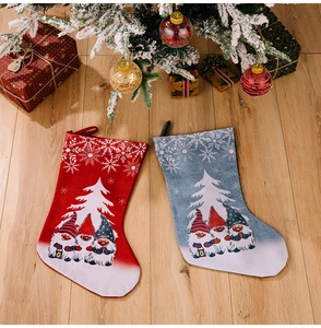 Flat lay of red and blue gnome Christmas stockings on light wood background