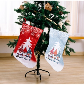 Detail of Rudolph gnome printed Christmas stockings hanging on a tree in a cozy setting