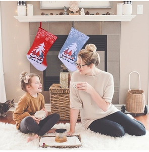 Detail of red and blue Christmas gnome stockings hanging on a festive mantel with snowflakes