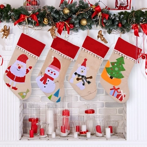 Set of four Christmas stockings with cartoon reindeer and Santa hanging on a fireplace