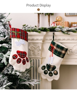 Detail von Weihnachtsstrümpfen in Pfotenform mit Karomuster am Kamin hängend