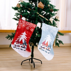 Large Christmas stockings with Rudolf gnomes and snowflake prints hung on a tree