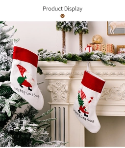 Close-up of white felt Christmas stockings with Santa embroidery on a mantelpiece