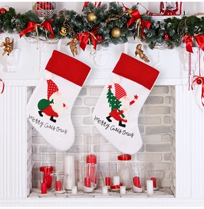 Detail of Christmas stockings with embroidered gnomes and Merry Christmas text on a mantel