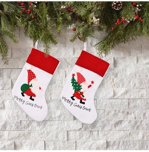 Detail of white Christmas stockings with gnome embroidery and Merry Christmas text