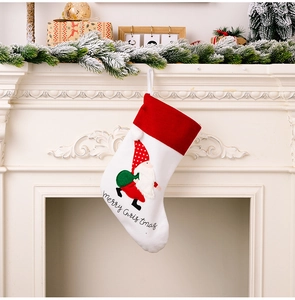 Detail of white Christmas stocking with embroidered gnome and Merry Christmas text