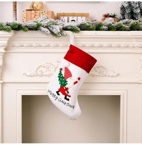 Detail of white Christmas stocking with gnome embroidery and Merry Christmas text