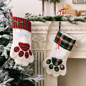 Weihnachtliche Hundepfoten-Strümpfe mit kariertem Rand am Kamin für Haustier-Geschenke