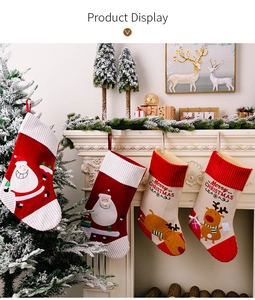 Close-up of four hanging Christmas stockings with Santa and reindeer on white fireplace