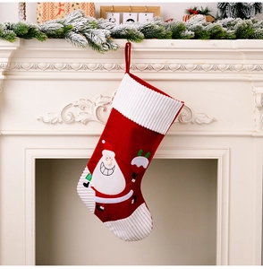 Detailed view of large Christmas stocking with 3D Santa decor on white fireplace