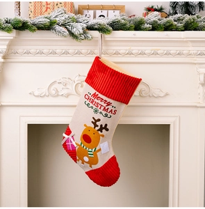 Close-up of Christmas stocking with cartoon reindeer hanging on fireplace mantel