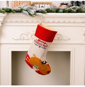 Detail of Christmas stocking with reindeer applique and Merry Christmas text hanging on a fireplace