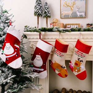 Set of 4 Christmas stockings with Santa and reindeer patterns hung by a warm fireplace