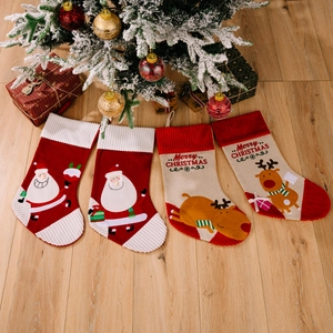 Set of 4 Christmas stockings with Santa and Reindeer designs on a wooden floor
