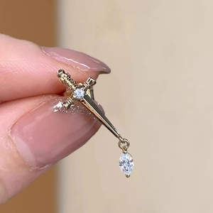 Golden sword ear stud with sparkling zircon crystals and a marquise drop pendant