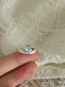 Détail macro d'une bague en zircon bleu ovale avec gravure de plumes sur l'anneau