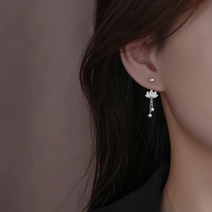 Elegant silver lotus tassel earrings with dangling chains on a female model's ear