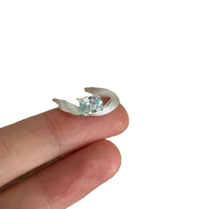 Bague minimaliste en argent avec texture de plume et zircon bleu ovale sur main