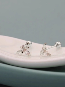 Macro detail of silver insect stud earring with pink zircon and screw back closure