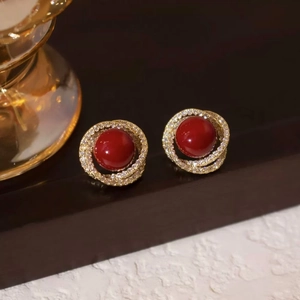 Orecchini vintage con perla rossa, base a spirale dorata e pavé di zirconi