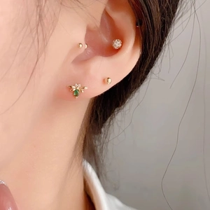 Elegant gold bee stud earring with green zircon and sparkling crystals on model ear