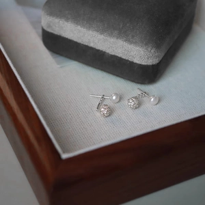 Elegant pearl and pave cubic zirconia stud earrings with silver-toned metal finish