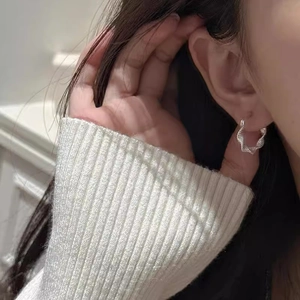 Silver twisted rope hoop earrings with a textured mobius design worn by a female model