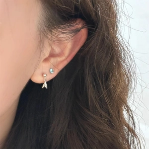 Detailansicht von Silber-Meerjungfrau-Ohrstecker und blauem Zirkon-Ohrring am Ohr