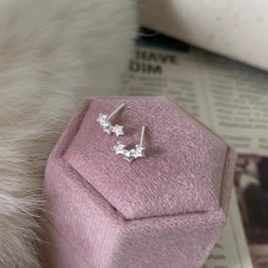 Boucles d'oreilles étoiles en argent avec zircons sur boîte en velours rose et fourrure