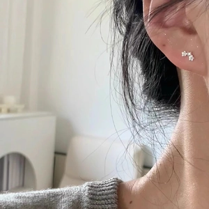 Boucles d'oreilles étoiles minimalistes en argent avec finition polie sur une oreille