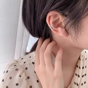 Minimalist gold multi-layer ear cuff with zircon accents worn on model's ear