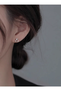 Close-up of elegant silver heart stud earrings with a sparkling zircon stone for women