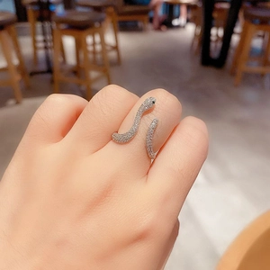 Close-up of snake ring with pave white zircons and black gemstone eyes on hand