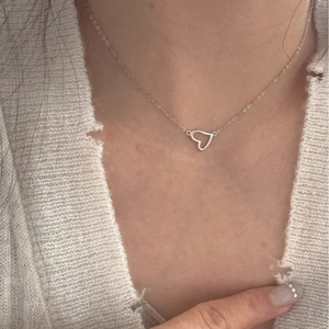 Collana con ciondolo a cuore minimalista in argento con catena sottile indossata da modella