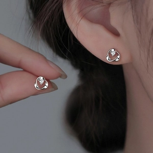 Silver Mobius heart stud earrings with sparkling cubic zirconia on a female model