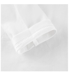 Détail des coutures fines et du tissu en coton tricoté blanc sur une manche pour enfant