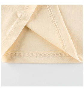 Dettaglio ravvicinato della doppia cucitura e dell'orlo su t-shirt beige per bambini