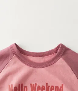 Detail of pink cotton raglan sleeve shirt with Hello Weekend print and ribbed neckline