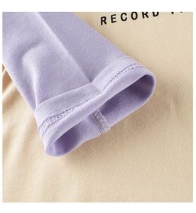 Detailed macro view of the ribbed cuffs and soft cotton fabric of a long-sleeve tee